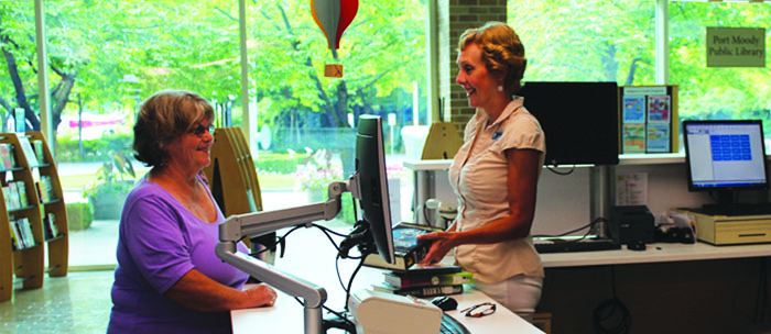 women talking at the Library counter