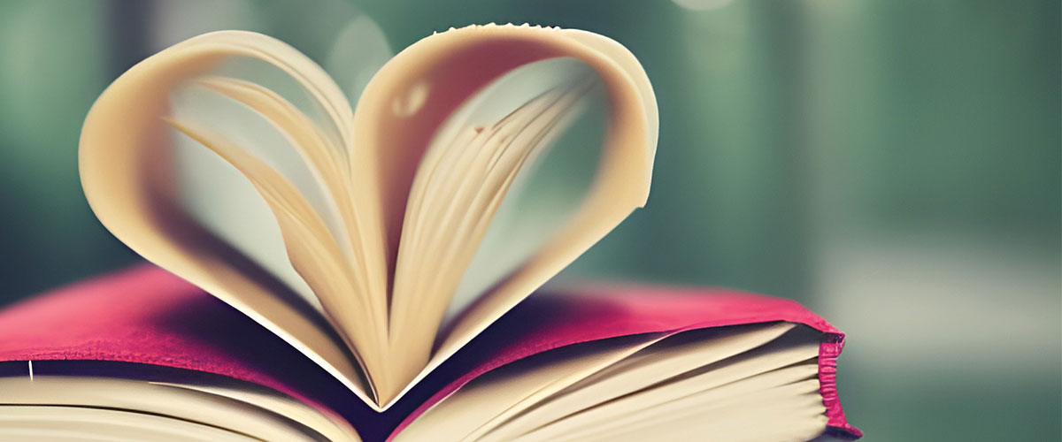 An open book with the pages curled into the shape of a heart.