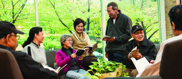 group of men and women holding books and talking to each other