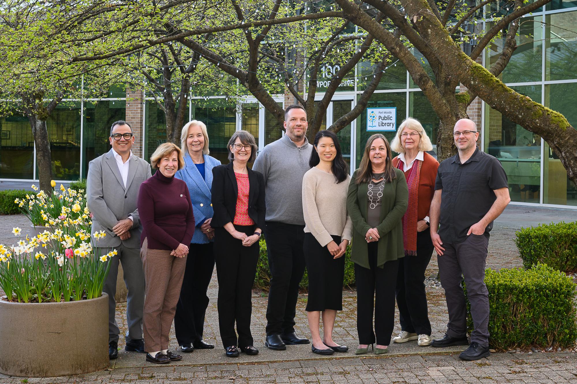 Photo of nine board members standing outside the Port Moody library